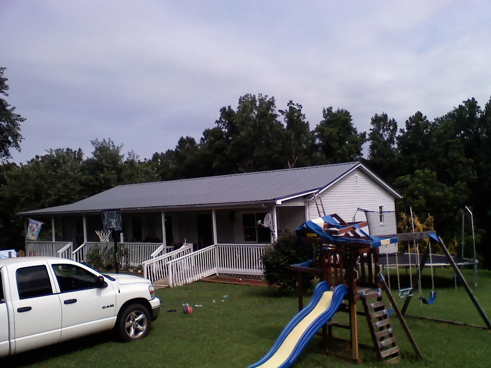 Dark metal roof on a country home with a full length front porch in Bristol